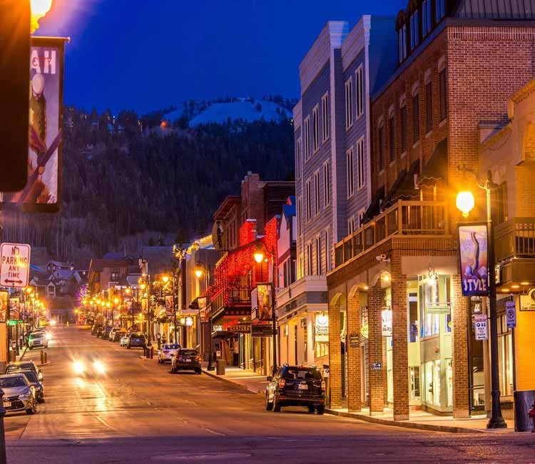 a city street with a lot of traffic with Summit Slopes luxury transportation.
