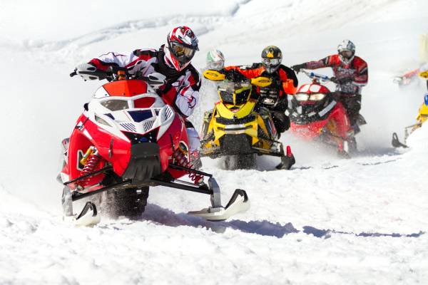a man riding a snowboard down a snow covered slope with Summit Slopes luxury transportation.