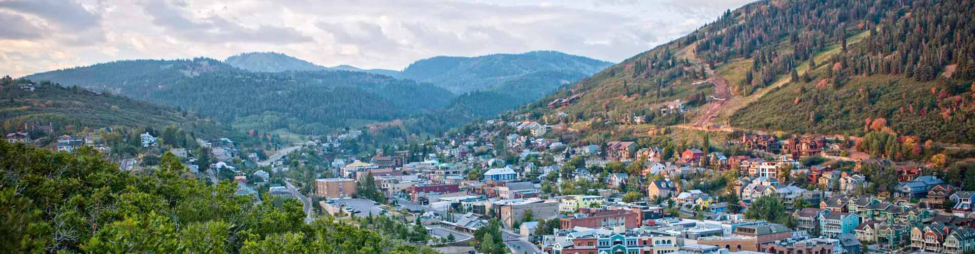 a city with a mountain range and mountains with Summit Slopes luxury transportation.