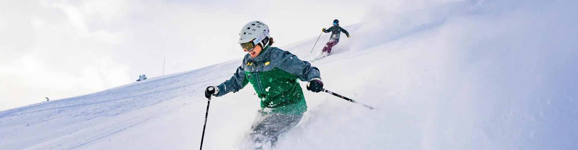 a skier is going down a hill on a sunny day with Summit Slopes luxury transportation.